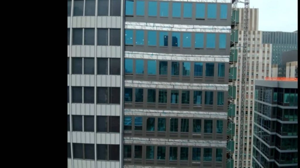 0 An urban high rise building with a modern architectural design characterized by extensive glass windows and a prominent