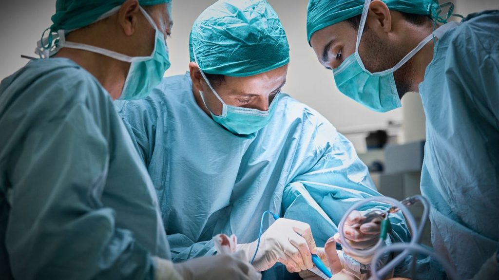0 Surgeons operating patient for breast implant