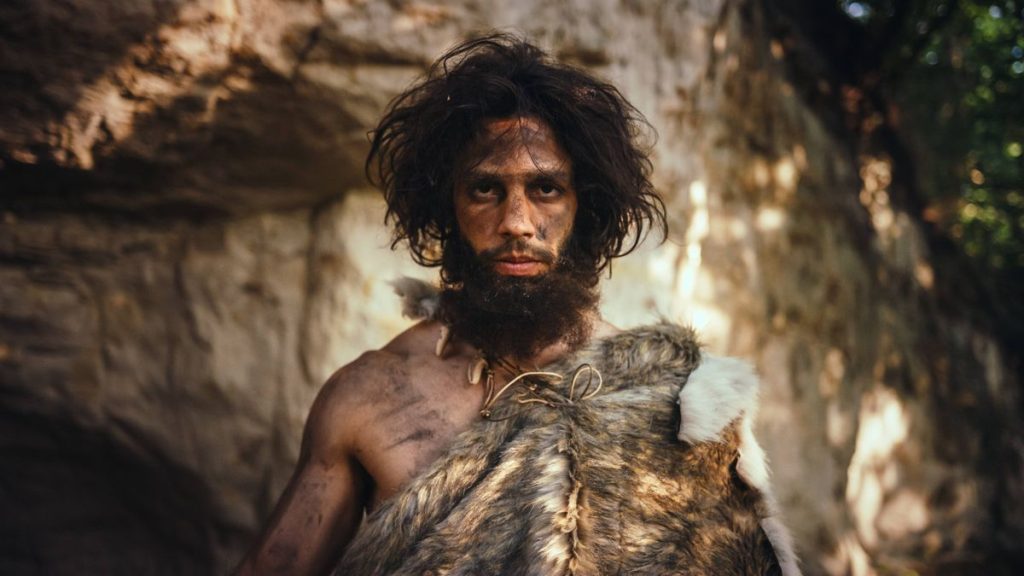 1 Portrait of Primeval Caveman Wearing Animal Skin Holding Stone Tipped Hammer Prehistoric Neanderthal Hunter Posing wit