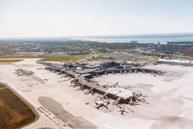 0 Aerial view of Montreal airport terminal with aircraft on the runway under clear summer sky g