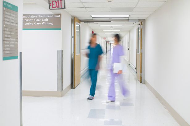 0 Blurred view of nurses walking in hospital hallway