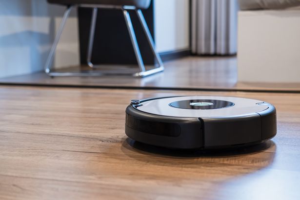 0 Robotic vacuum cleaner working on laminate wooden floor