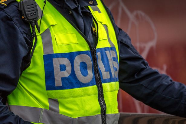 1 Close up of Swedish police officer wearing a luminous yellow green vest with police