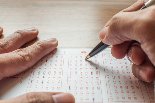 0 Close up of hands filling up a lottery ticket form